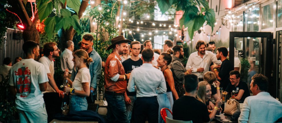 Guests talking under string lights at Torino Connect #9